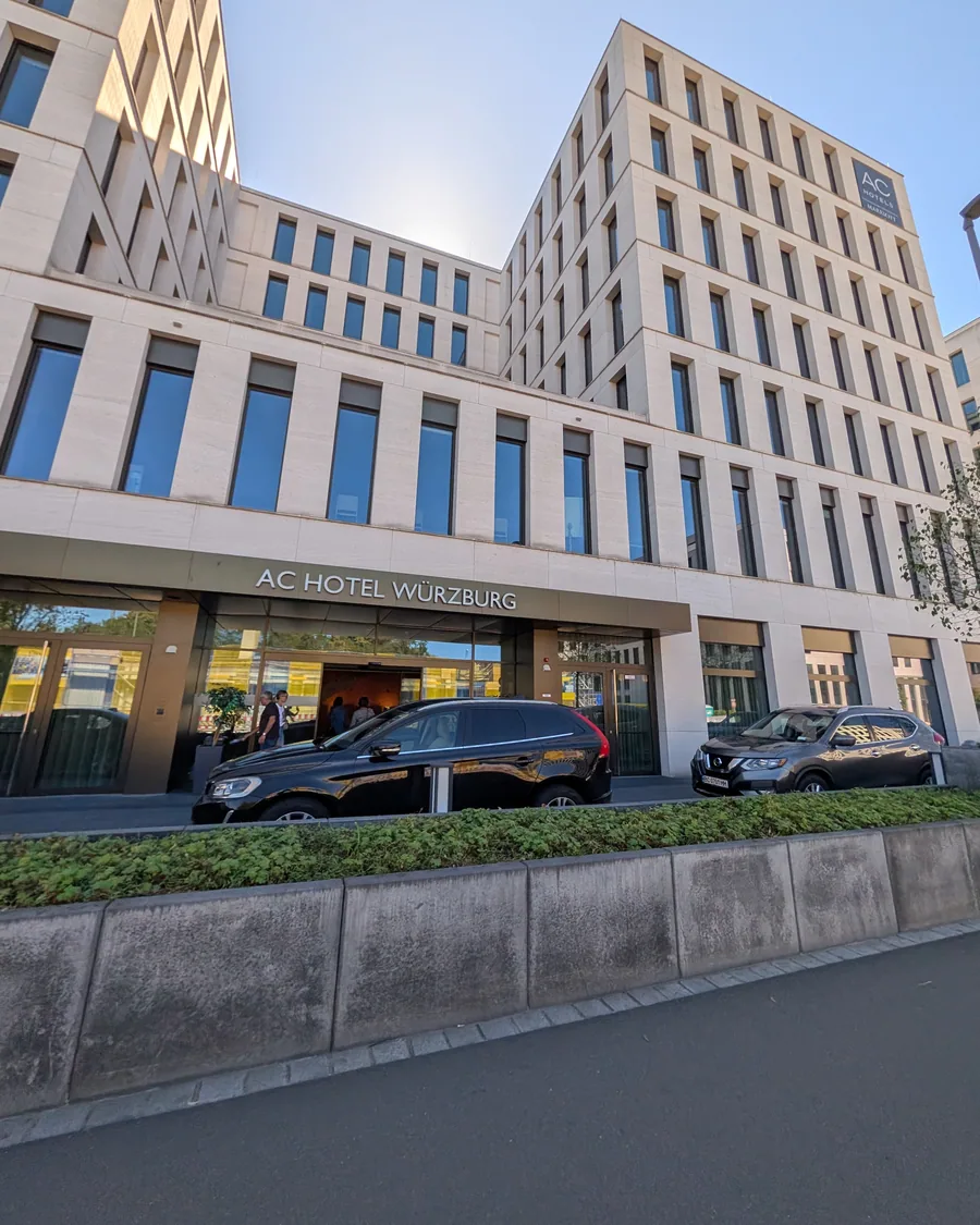 Der Eingang des AC Hotel Würzburg an der Schweinfurter Straße, darüber die Fassade aus hellem Stein