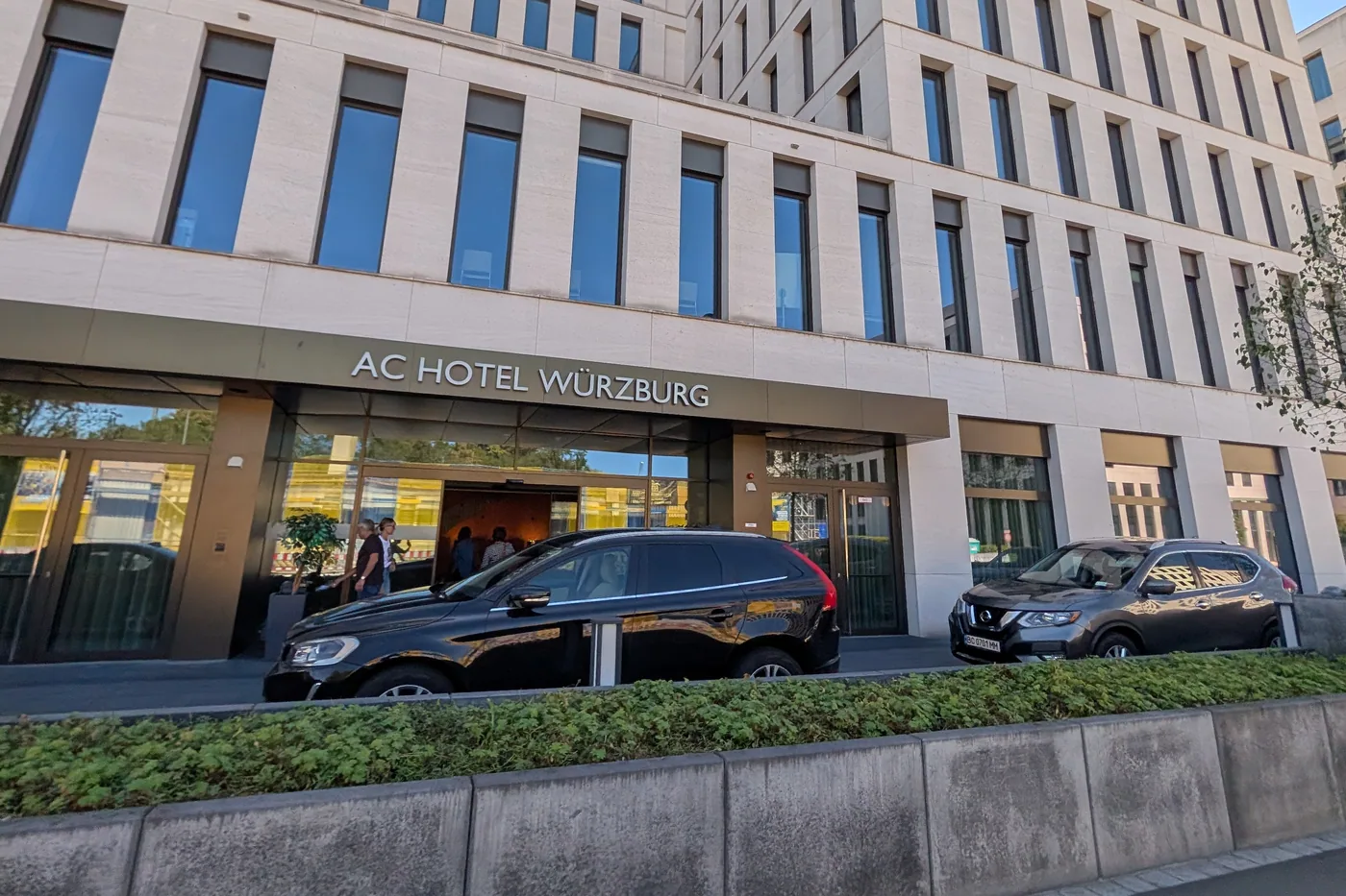Der Eingang des AC Hotel Würzburg an der Schweinfurter Straße, darüber die Fassade aus hellem Stein
