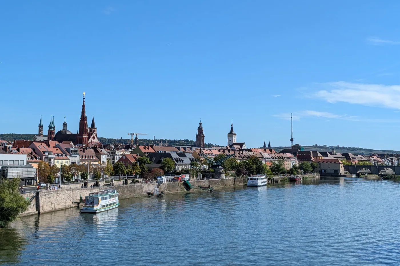 Die Würzburger Altstadt vom Main aus, mit Ausflugsschiffen am Kai, dem Alten Kranen und der Alten Mainbrücke rechts