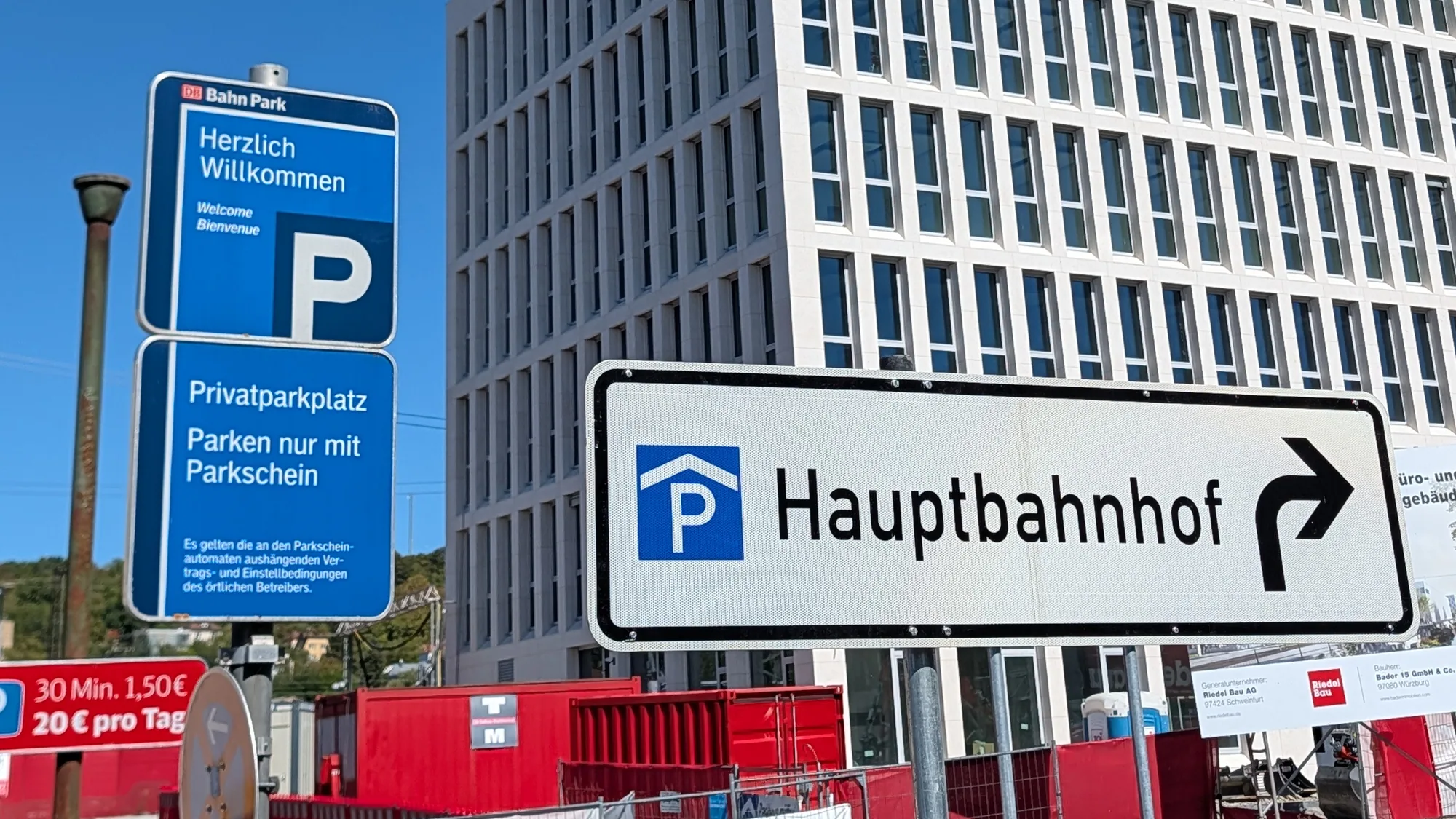 Das Schild von DB Bahn Park am Bahnhofplatz: Privatparkplatz, Parken nur mit Parkschein, daneben der Wegweiser zum Parkhaus Hauptbahnhof