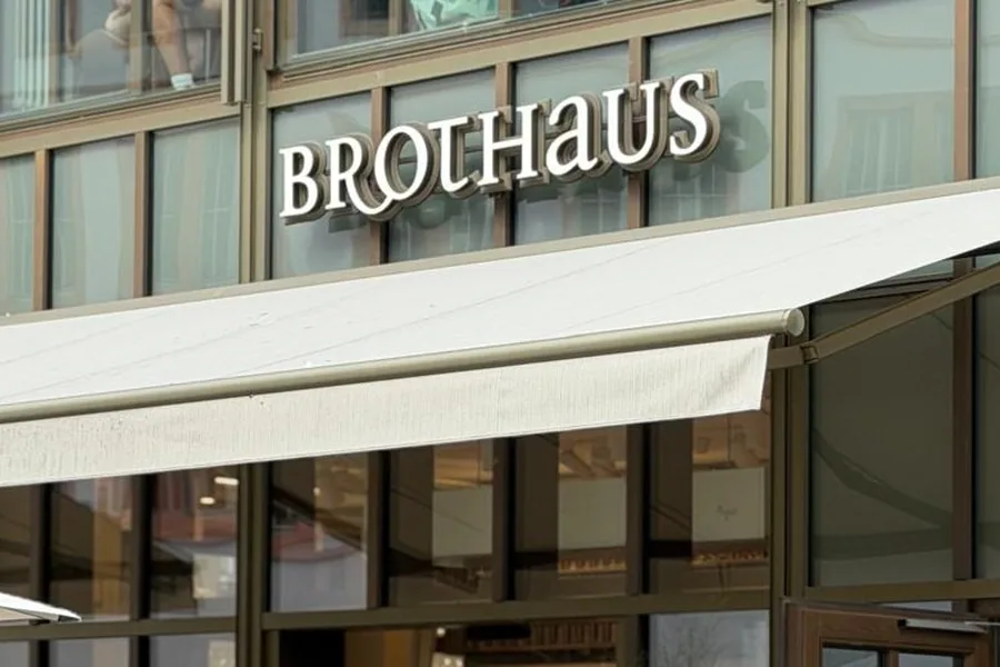 Der Schriftzug BROTHAUS in weißen Buchstaben über der Glasfassade am Würzburger Marktplatz, darunter die ausgefahrene Markise