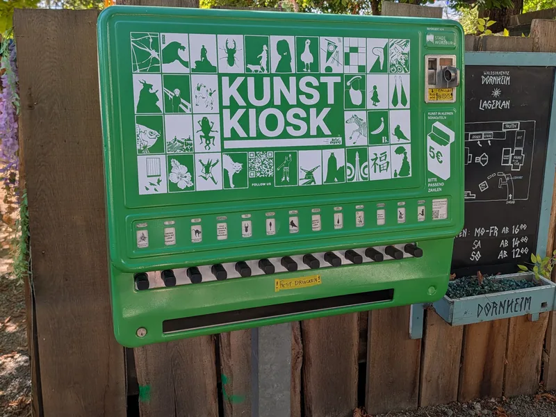 Der grüne Kunstkiosk am Zaun der Waldschänke, ein umgebauter Zigarettenautomat mit Kunst in kleinen Schachteln für fünf Euro