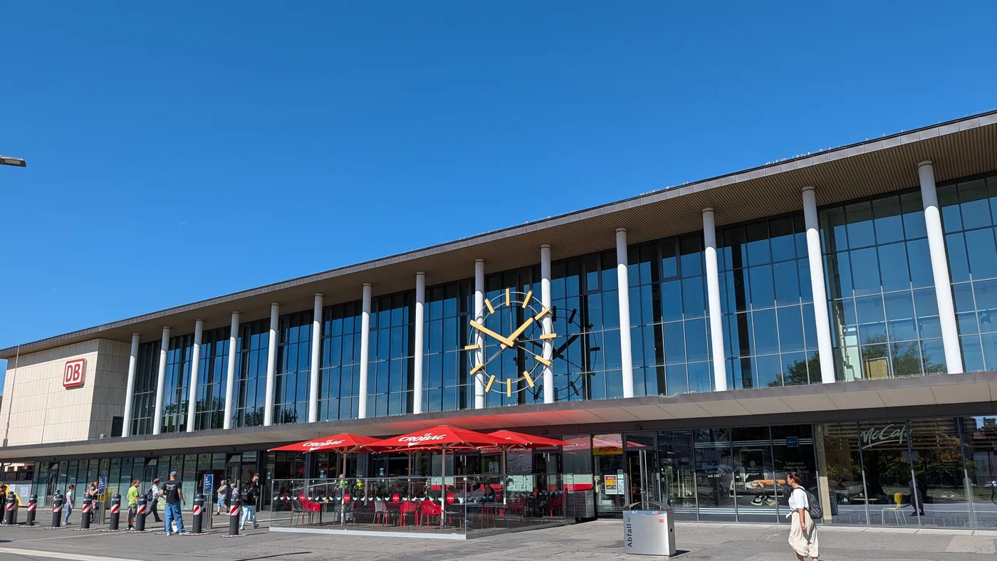 Die Glasfassade des Wuerzburger Hauptbahnhofs mit der grossen Bahnhofsuhr ueber dem Eingang