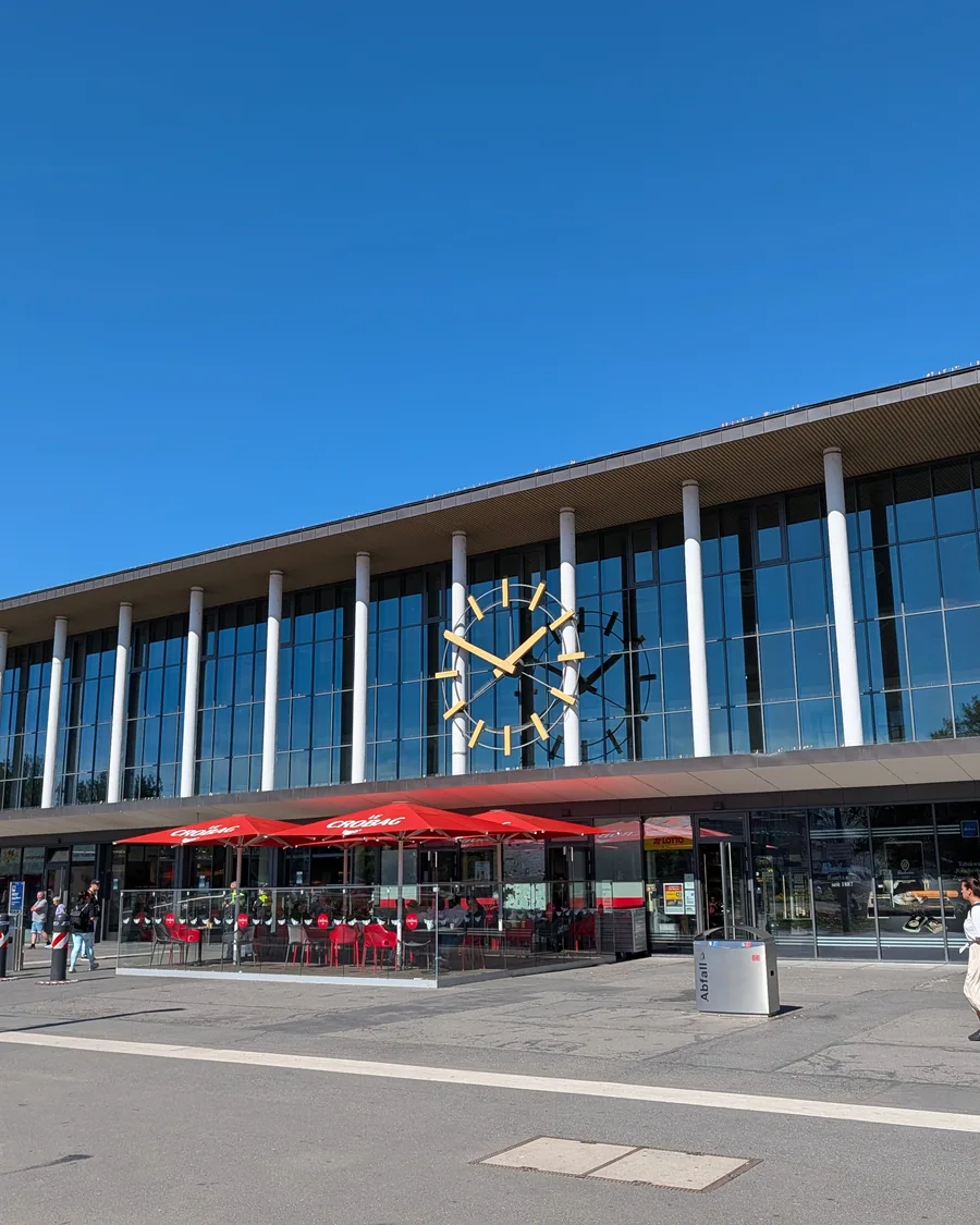 Die Glasfassade des Wuerzburger Hauptbahnhofs mit der grossen Bahnhofsuhr ueber dem Eingang