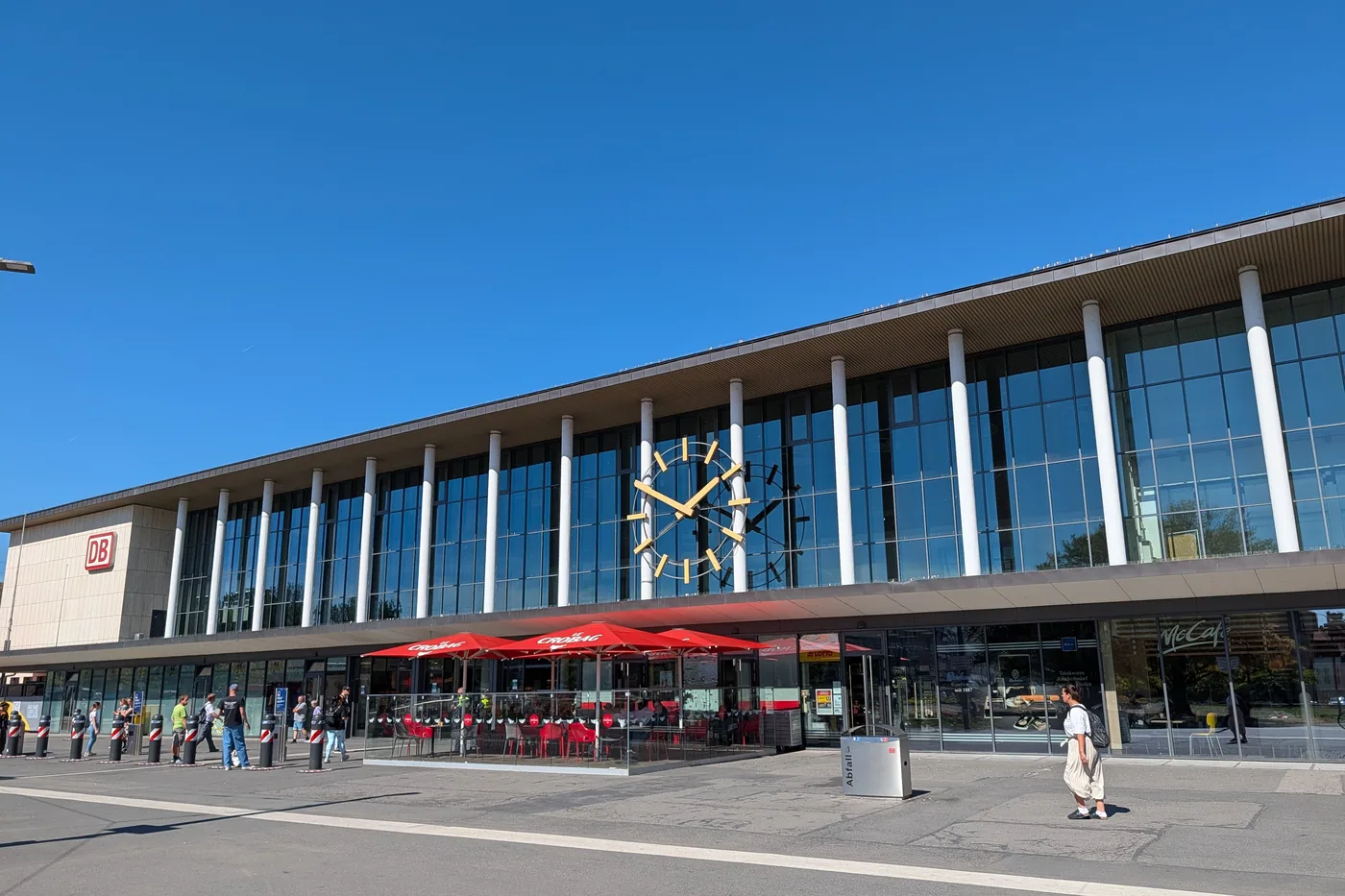 Die Glasfassade des Wuerzburger Hauptbahnhofs mit der grossen Bahnhofsuhr ueber dem Eingang