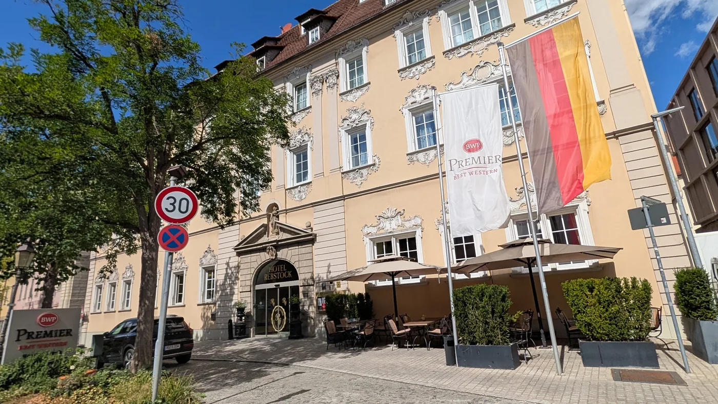 Das Hotel Rebstock in der Würzburger Neubaustraße, Rokokofassade mit Stuckdekor über drei Geschossen, davor die Terrasse mit Sonnenschirmen