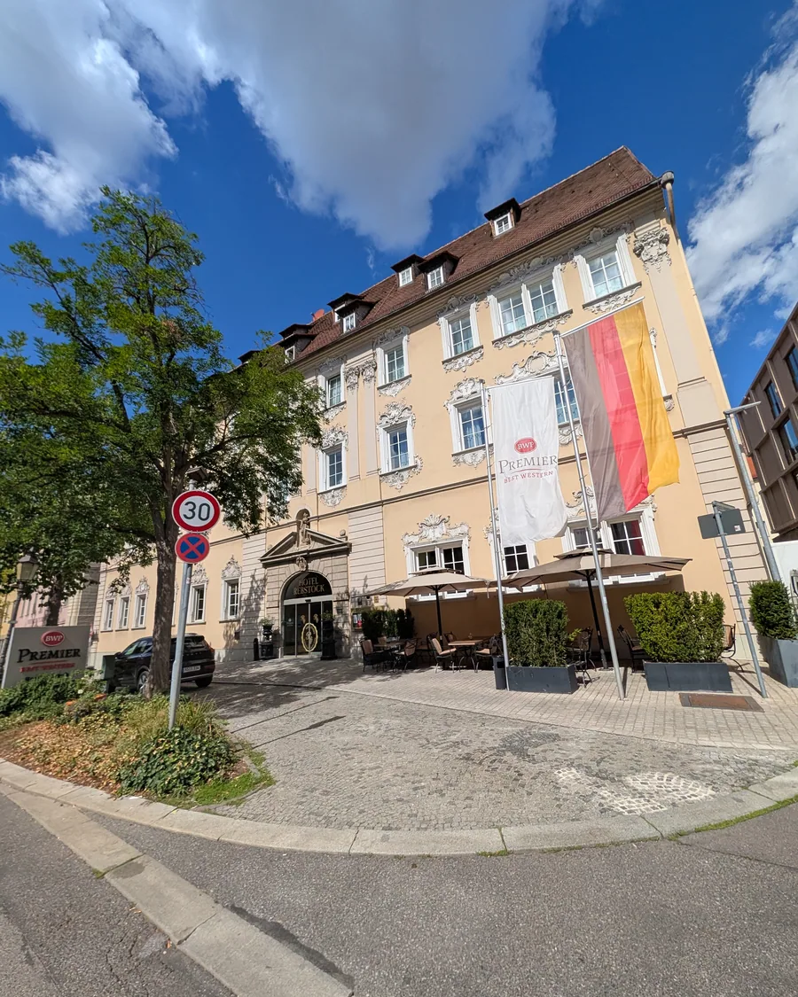 Das Hotel Rebstock in der Würzburger Neubaustraße, Rokokofassade mit Stuckdekor über drei Geschossen, davor die Terrasse mit Sonnenschirmen