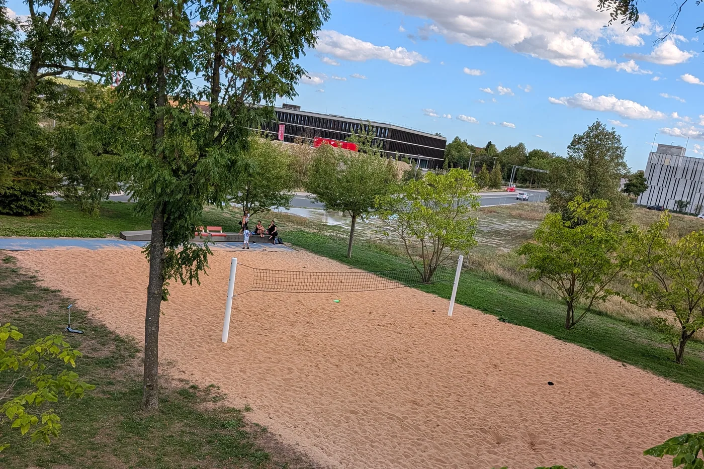 Ein Beachvolleyballfeld mit Netz auf dem Hubland, dahinter ein Gebäude der Hochschule