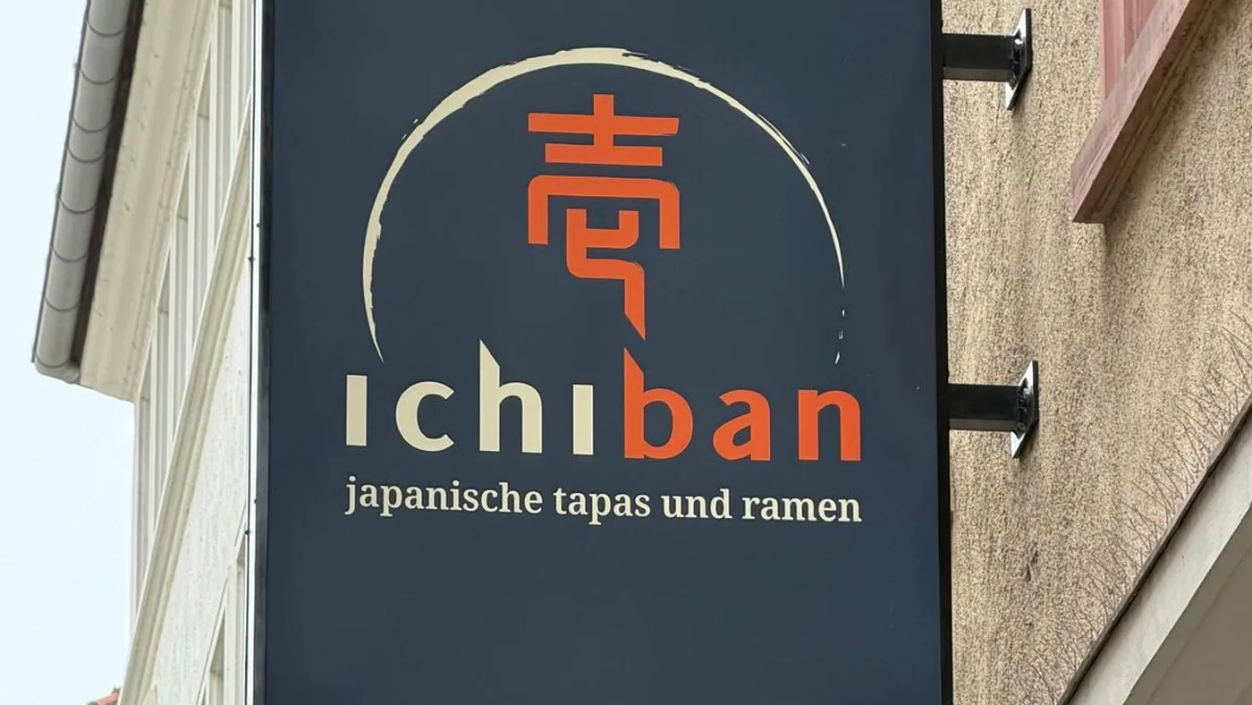 Das dunkelblaue Auslegerschild des Ichiban mit einem japanischen Schriftzeichen im Pinselkreis und der Zeile japanische tapas und ramen