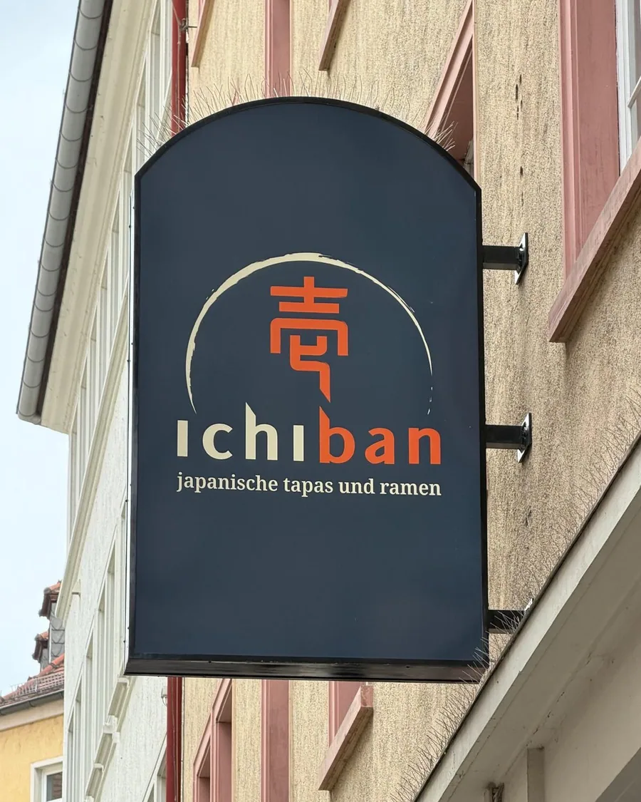 Das dunkelblaue Auslegerschild des Ichiban mit einem japanischen Schriftzeichen im Pinselkreis und der Zeile japanische tapas und ramen