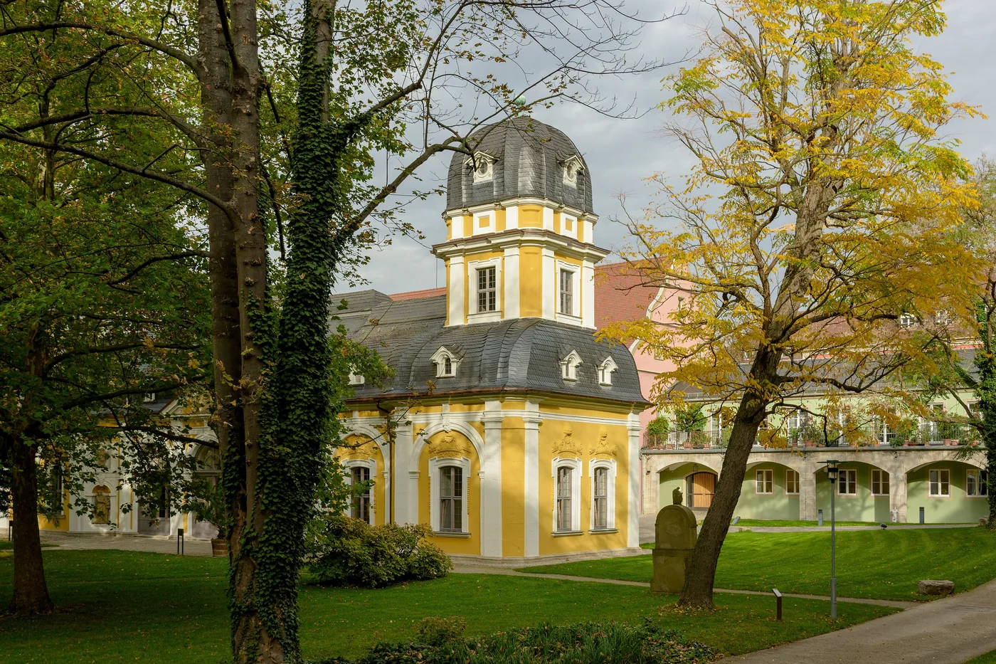 Gartenpavillon des Juliusspitals mit Zwiebelhaube, umgeben von Bäumen im Herbst