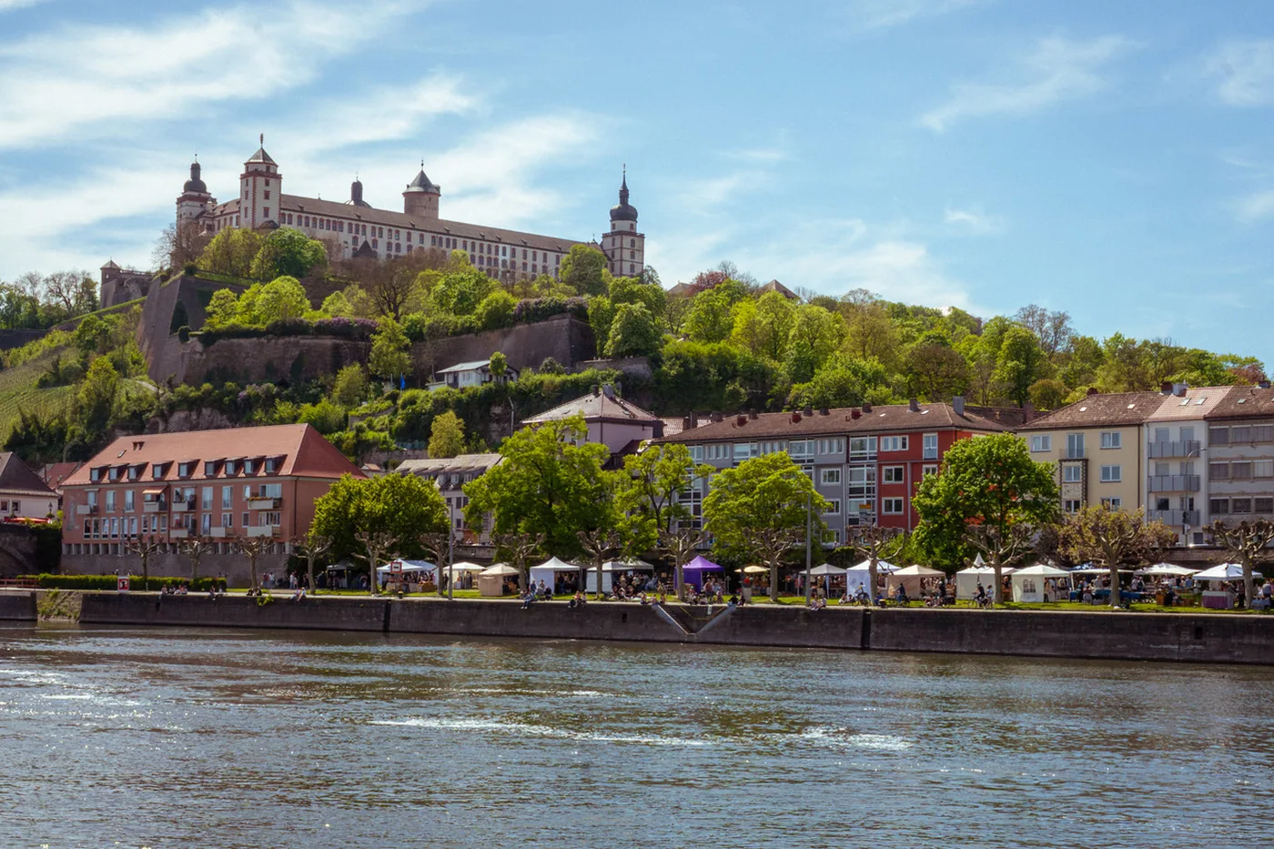 Der Kunsthandwerkermarkt an der Leonhard-Frank-Promenade, vom anderen Mainufer aus gesehen, darüber die Festung Marienberg