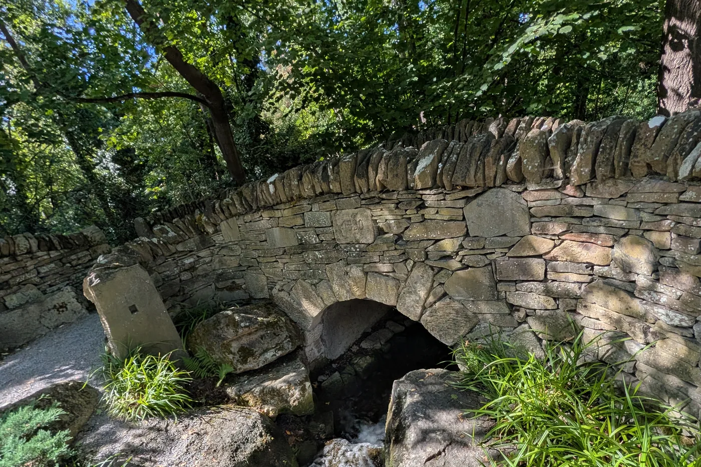 Eine Brücke aus Trockenmauerwerk über dem Bachlauf