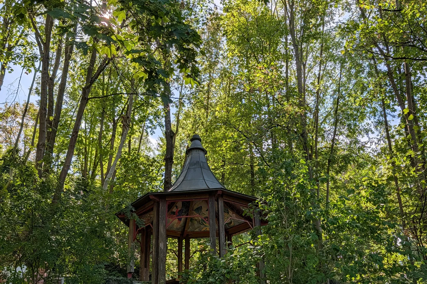 Der hölzerne Handwerkerpavillon unter Kastanien, mit Wappenscheiben an der Brüstung