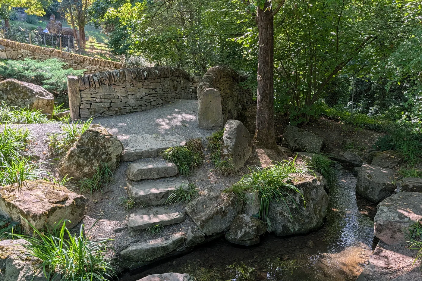 Trittsteine über dem Wasserlauf, eingefasst von Bruchsteinmauern
