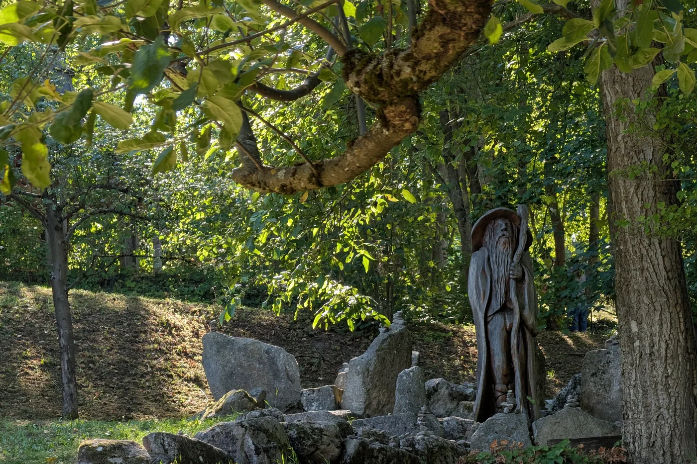 Eine geschnitzte Holzfigur am Wegrand, ein bärtiger Waldschrat