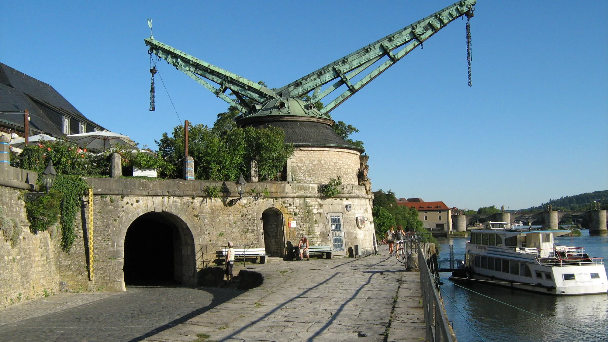 Ein Ausflugsschiff legt am Alten Kranen an, dahinter der Main