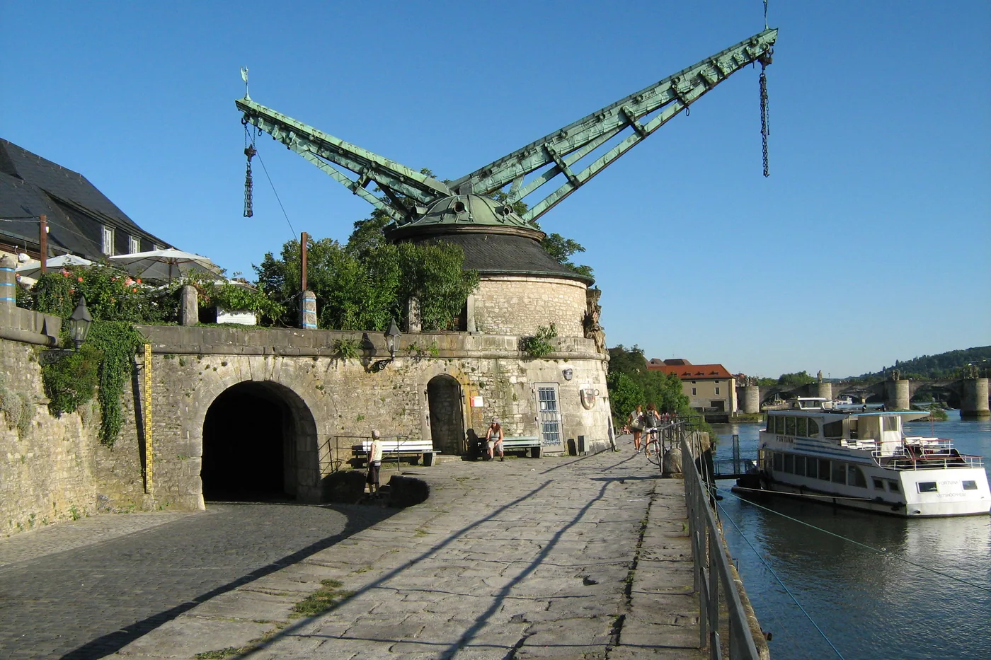 Ein Ausflugsschiff legt am Alten Kranen an, dahinter der Main