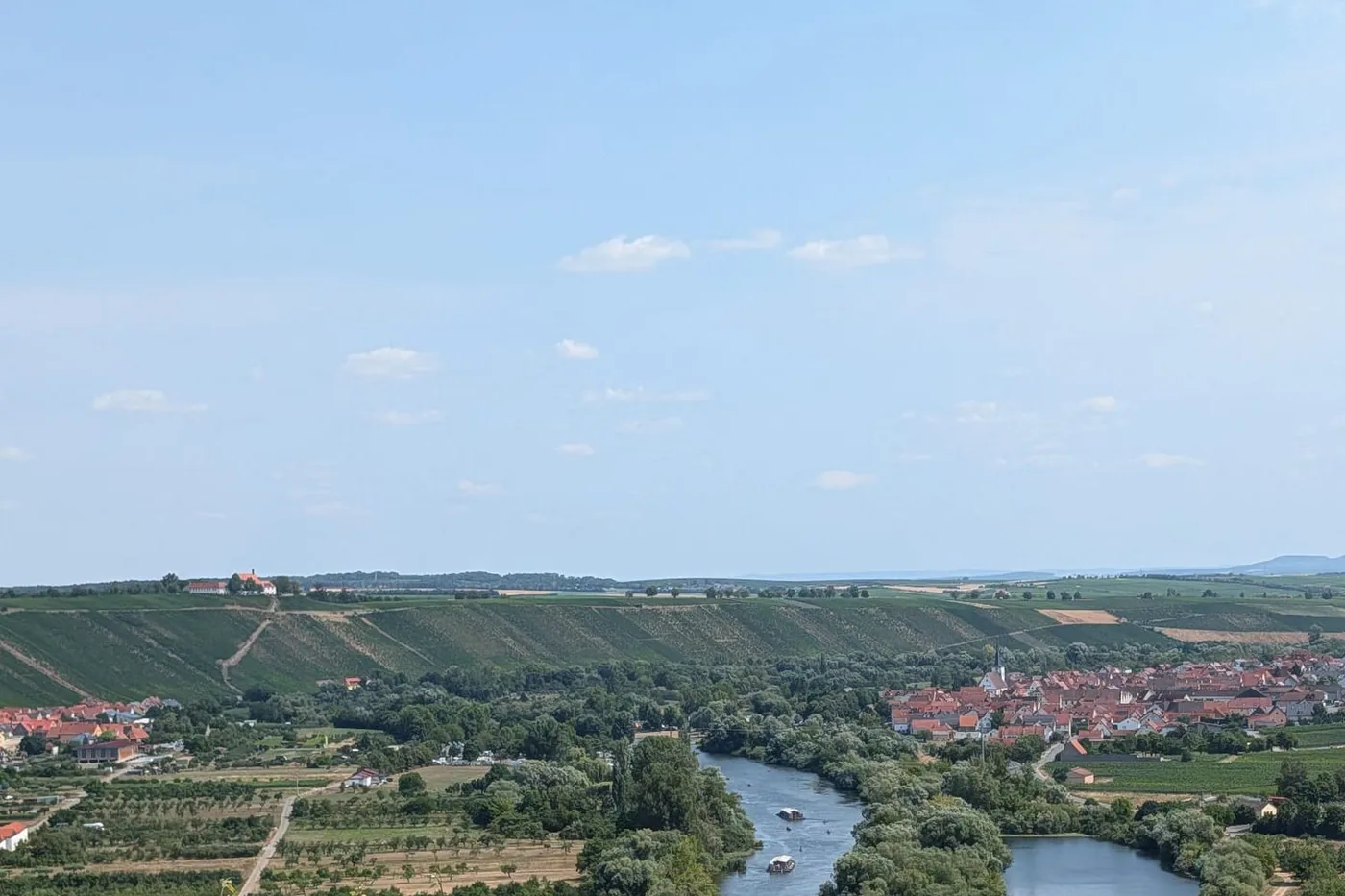 Weiter Blick über die Volkacher Mainschleife: links die Vogelsburg auf dem Höhenrücken, rechts Nordheim am Main, dazwischen der Fluss zwischen Weinbergen