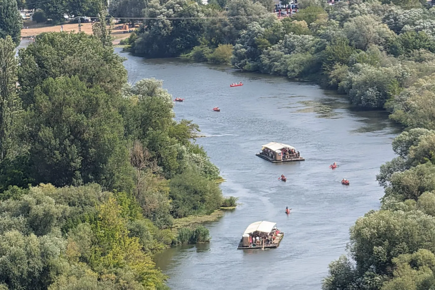 Zwei Flöße und ein Dutzend rote Kanus auf dem Altmain, von oben aus den Weinbergen gesehen