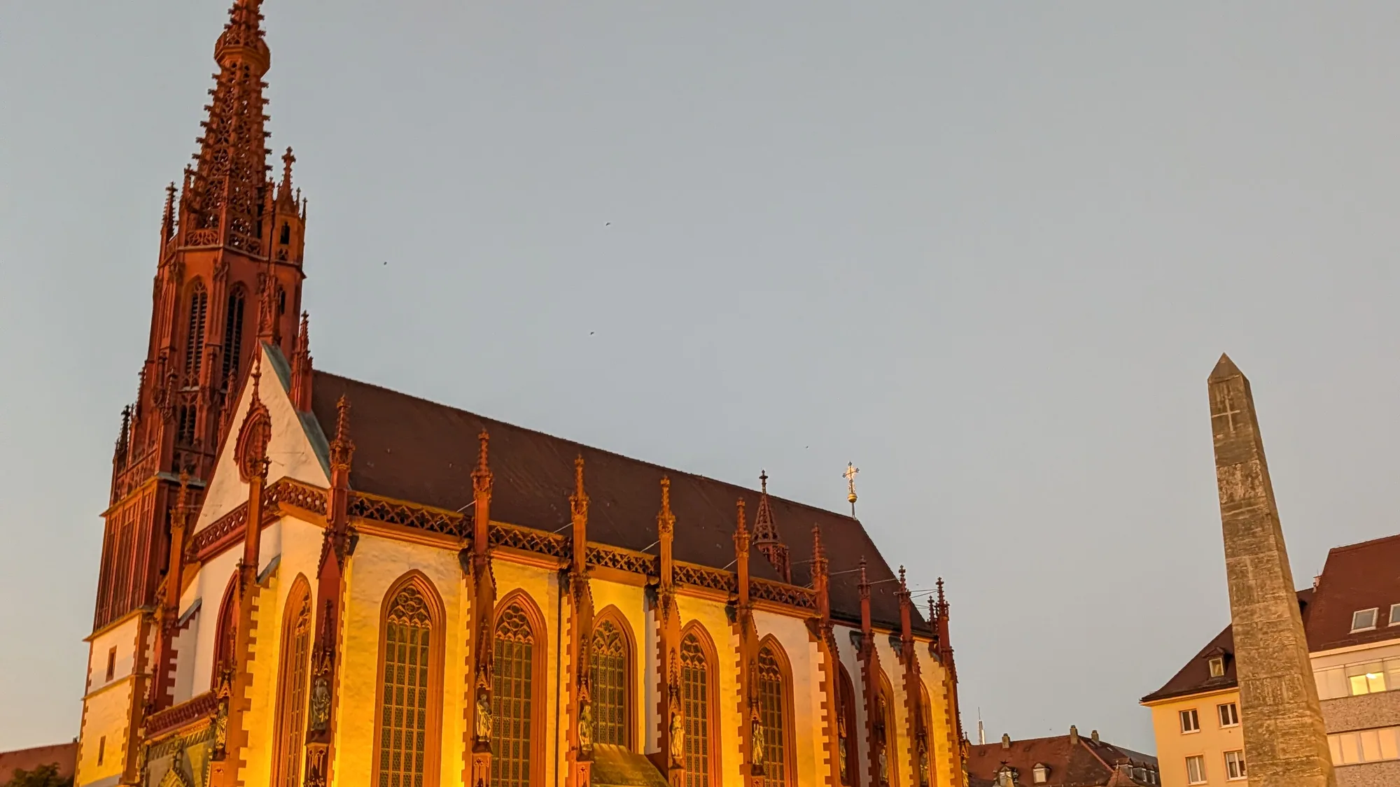 Die angestrahlte Marienkapelle am Würzburger Marktplatz, auf dem im Advent der Weihnachtsmarkt steht. Aufgenommen im September