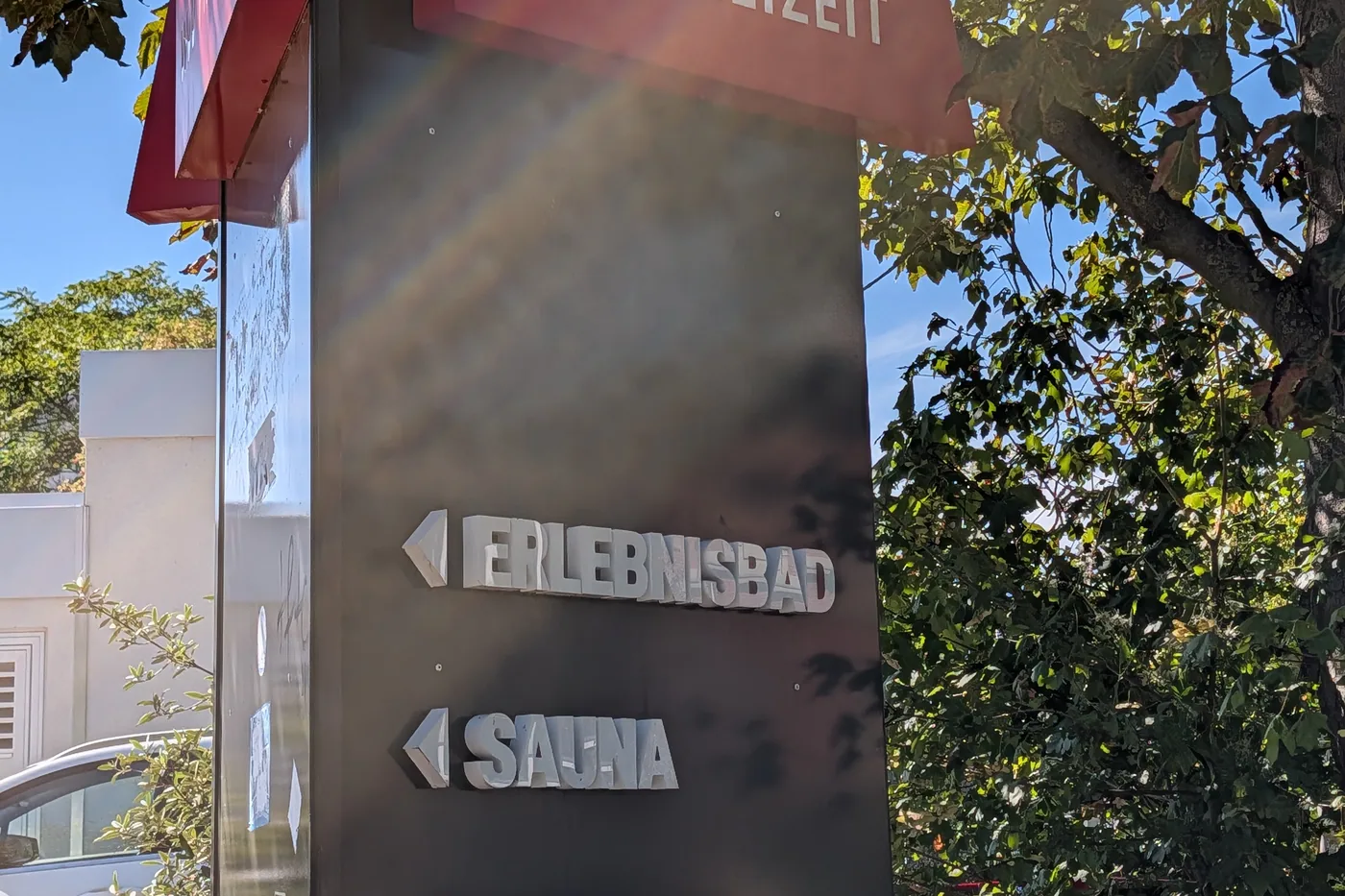 Die Wegweiser der Stele aus der Nähe: Erlebnisbad, Sauna und Eisbahn liegen alle links