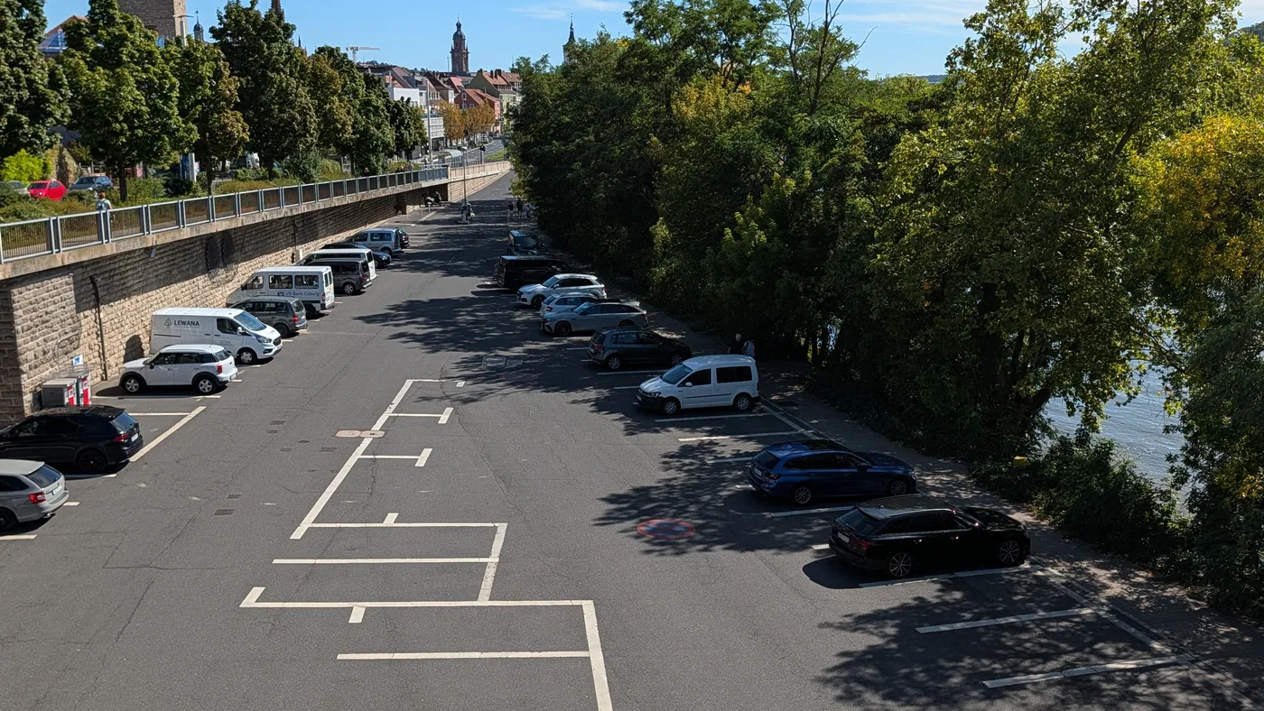 Der Parkplatz am Congress Centrum liegt zwischen der Stützmauer und dem Main, im Hintergrund die Türme der Würzburger Altstadt