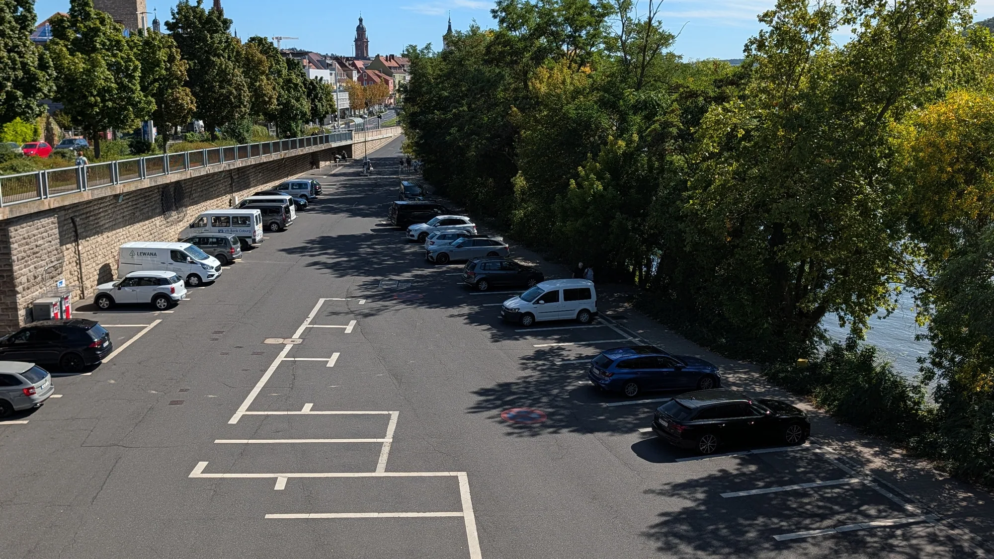 Der Parkplatz am Congress Centrum liegt zwischen der Stützmauer und dem Main, im Hintergrund die Türme der Würzburger Altstadt