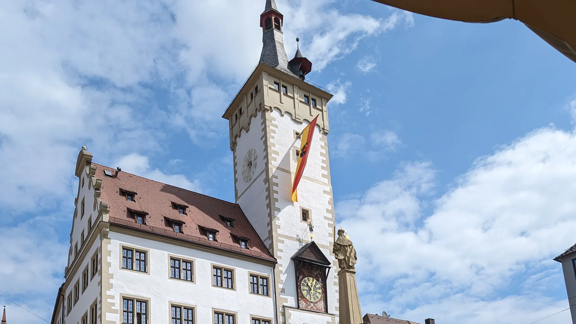 Der Vierröhrenbrunnen vor dem Würzburger Rathaus mit dem Turm des Grafeneckart