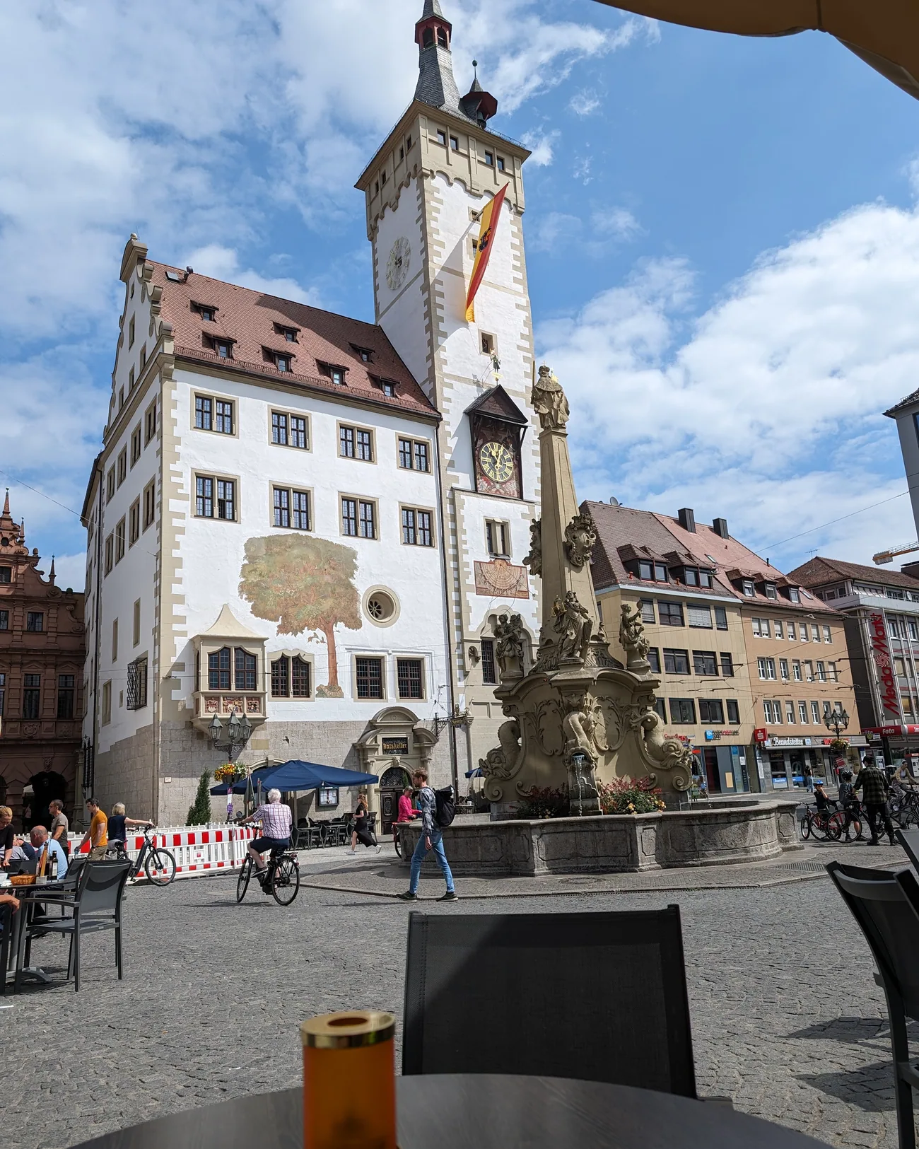 Der Vierröhrenbrunnen vor dem Würzburger Rathaus mit dem Turm des Grafeneckart