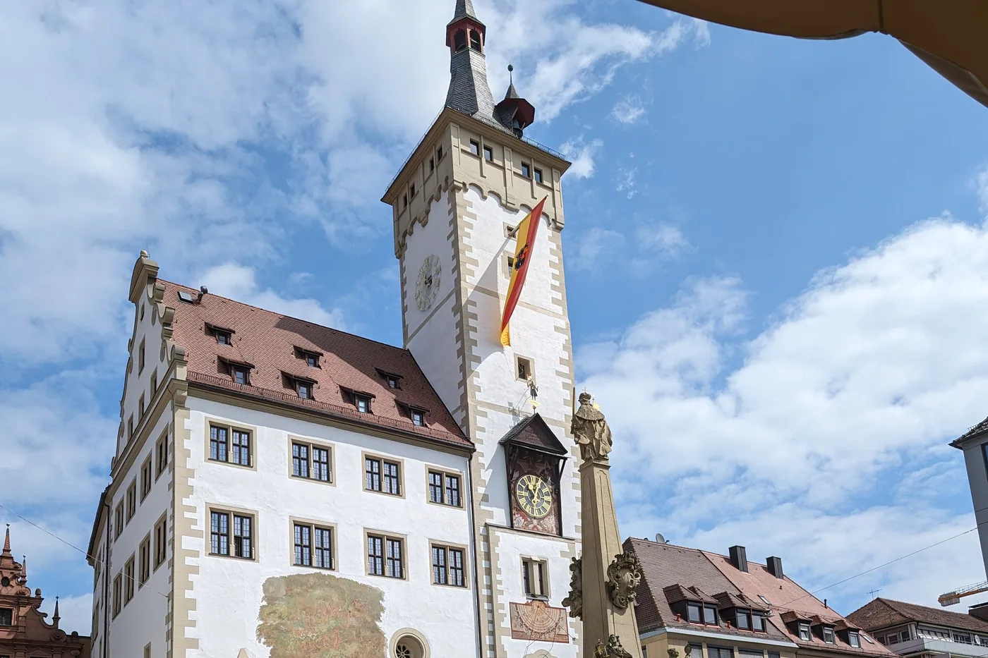 Der Vierröhrenbrunnen vor dem Würzburger Rathaus mit dem Turm des Grafeneckart