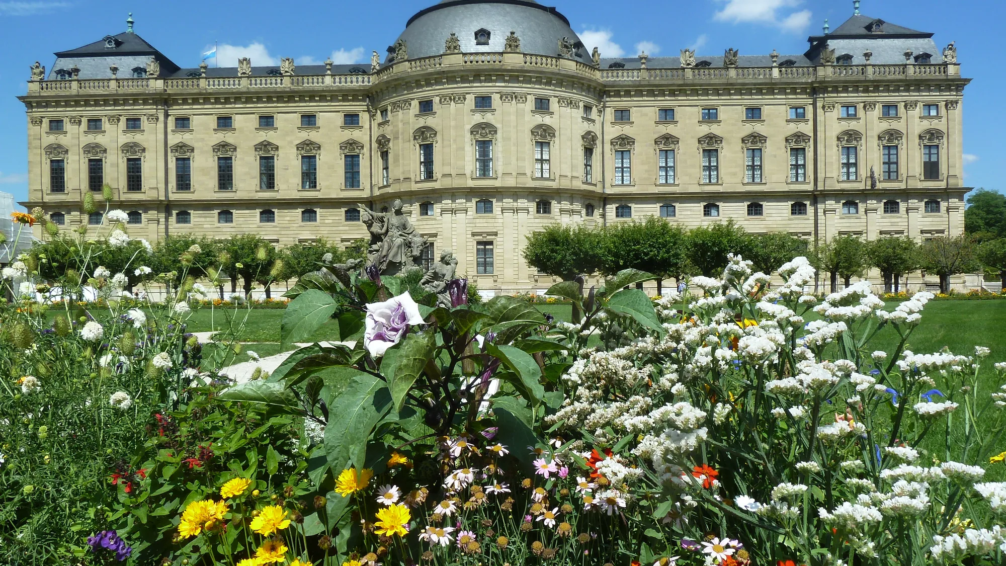 Die Residenz hinter einem blühenden Staudenbeet im Hofgarten
