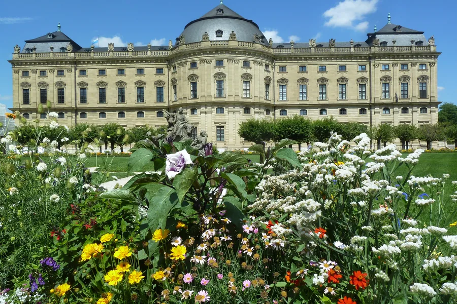 Die Residenz hinter einem blühenden Staudenbeet im Hofgarten