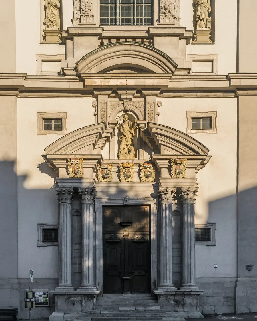 Die Barockfassade von Stift Haug mit Figurennischen und Säulenportal, von der Straße aus gesehen