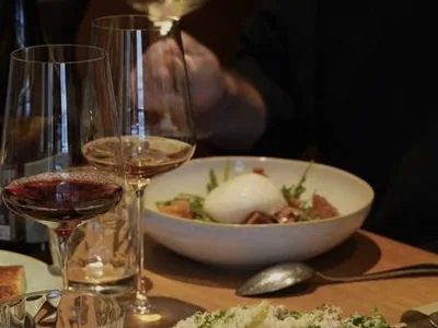 Abendlich gedeckter Tisch mit Wein- und Wassergläsern, davor zwei angerichtete Teller
